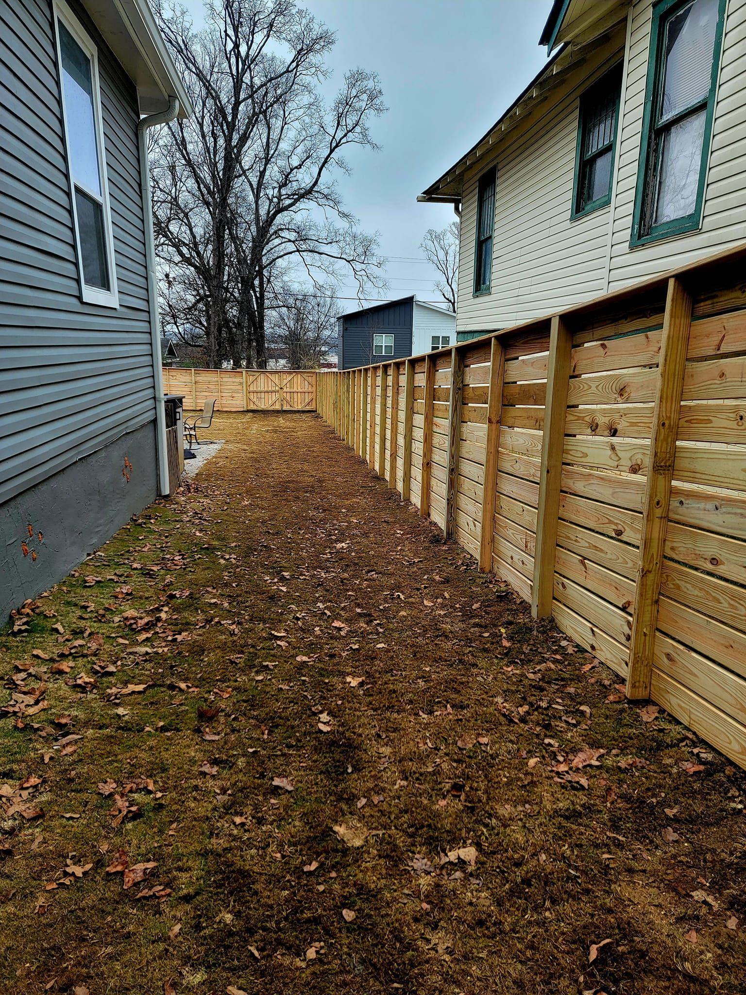 there is a wooden fence between two houses .