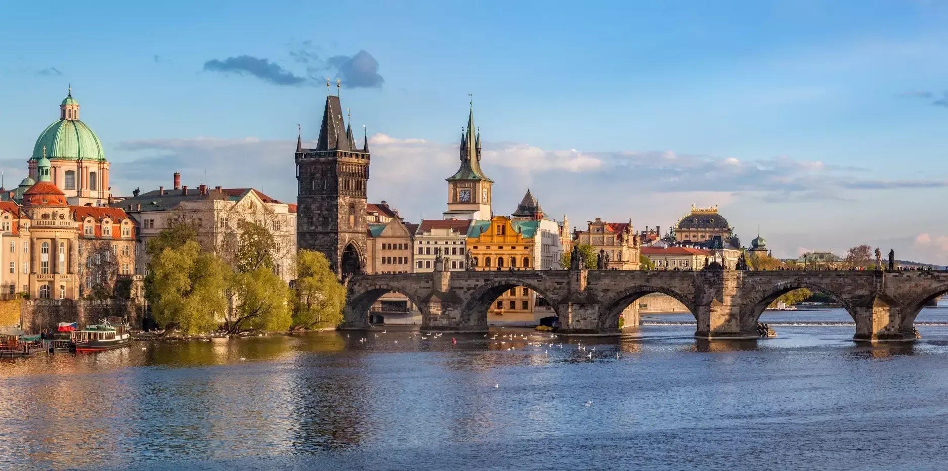 A city skyline with a bridge over a river in the foreground.