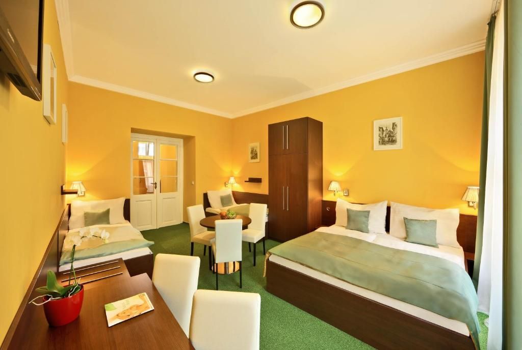 A hotel room with two beds , a table and chairs.