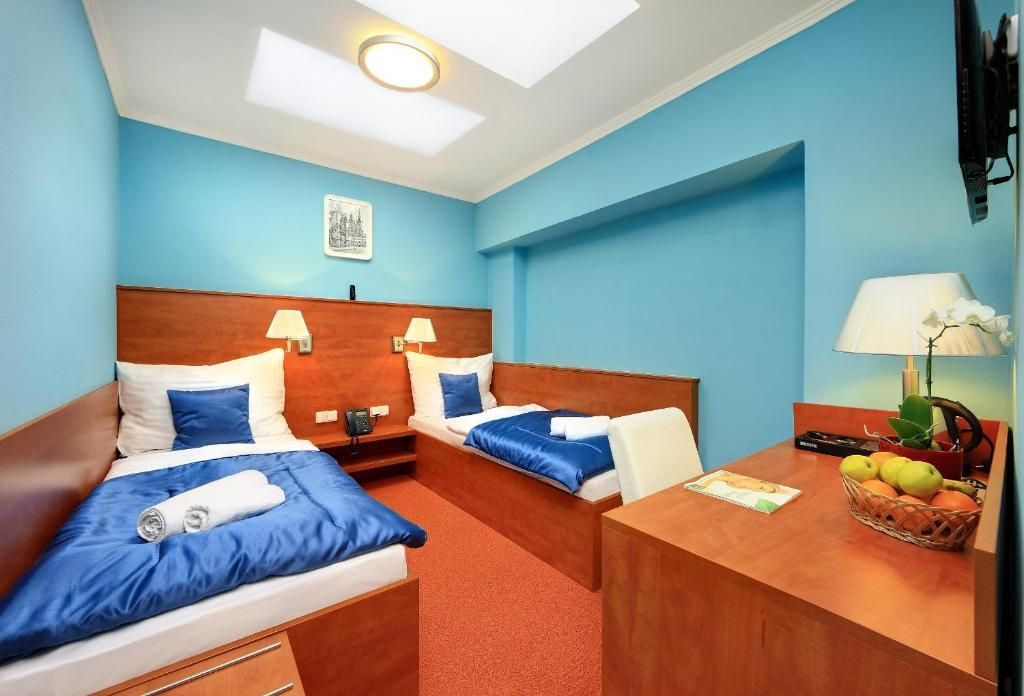 A hotel room with two beds , a desk and a television.