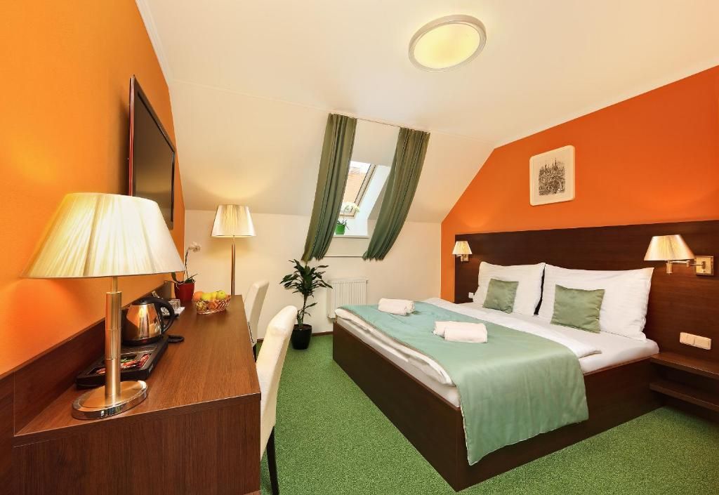 A hotel room with a large bed and a desk