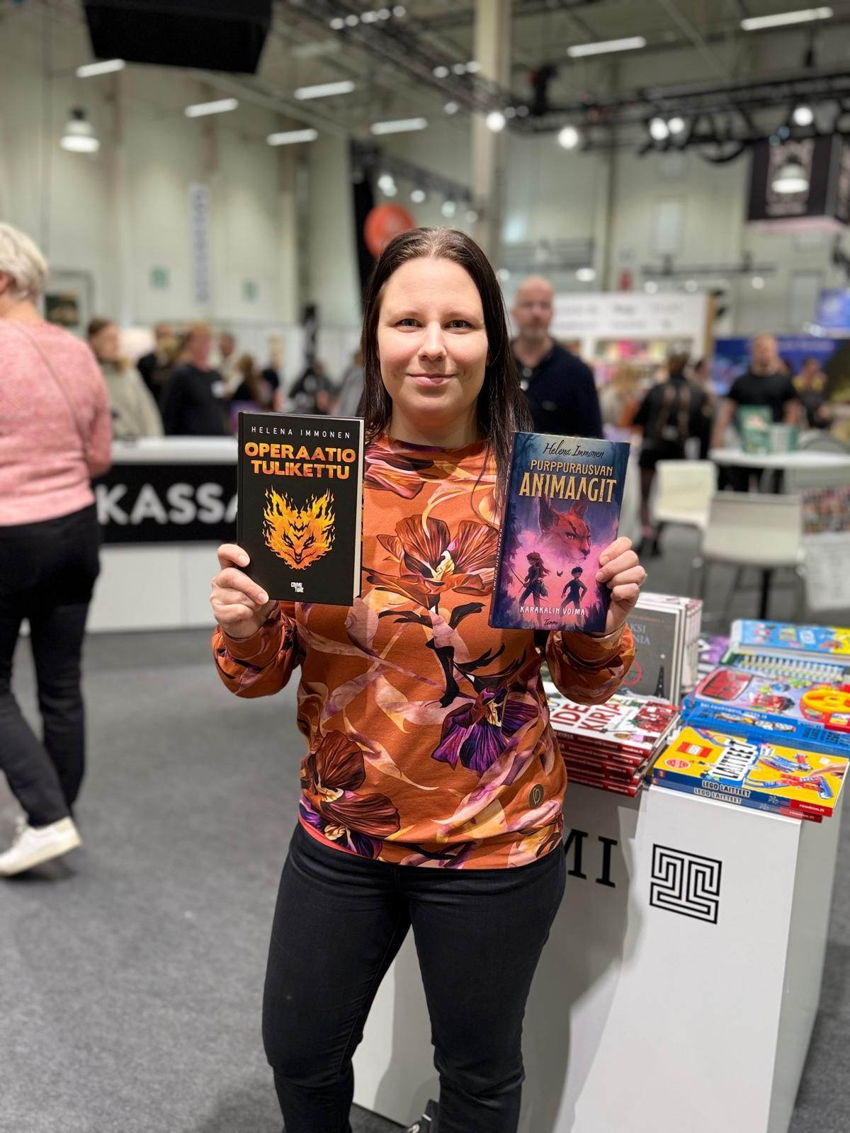 Kirjailija Helena Immonen kirjojen kanssa messuilla
