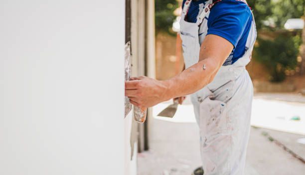 A man is plastering a wall with a spatula.