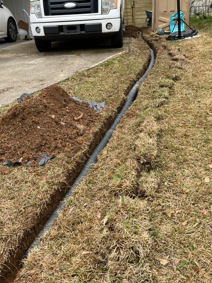 A white truck is parked in a driveway next to a drain.