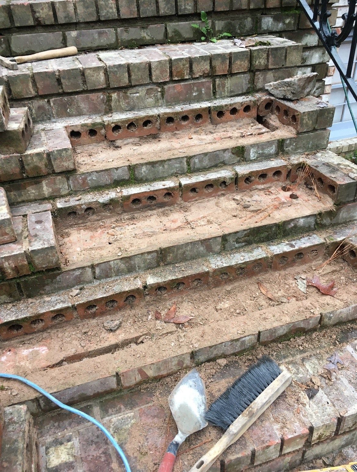 A brick staircase is being built with bricks and a brush.