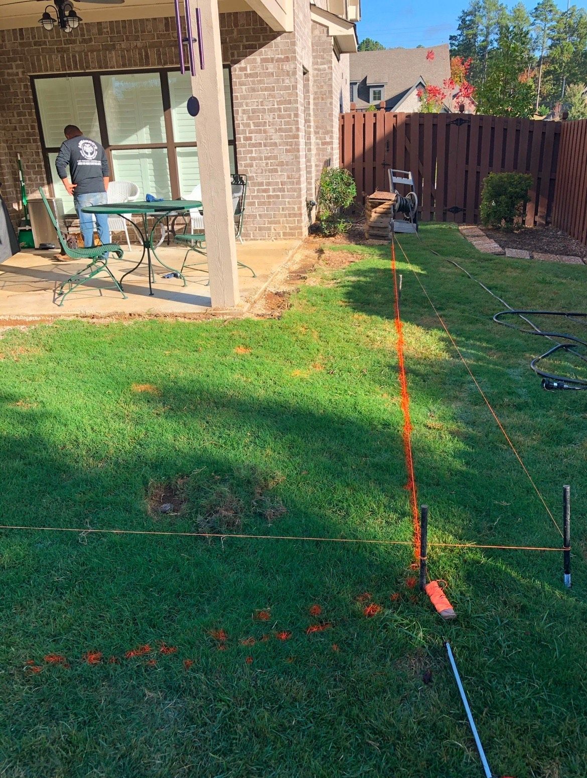 A man is standing in the grass in front of a house.