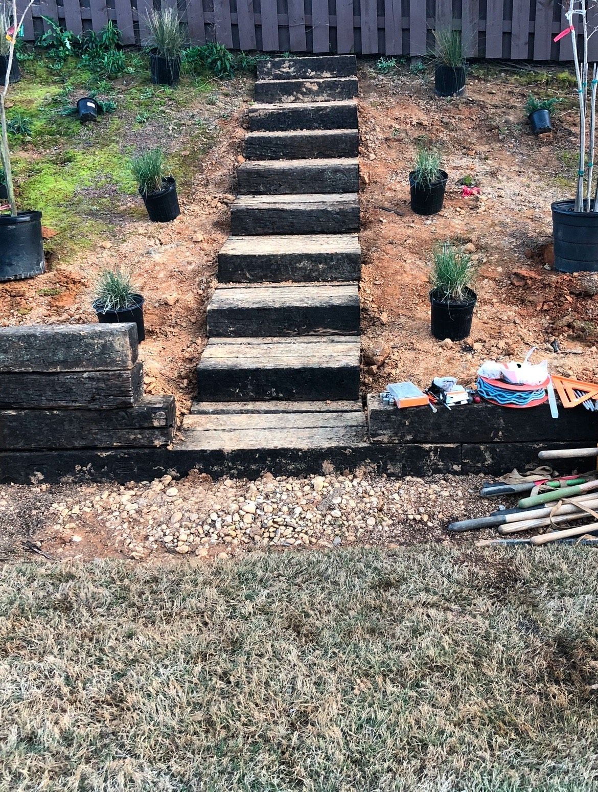 A set of stairs leading up to a garden with potted plants.