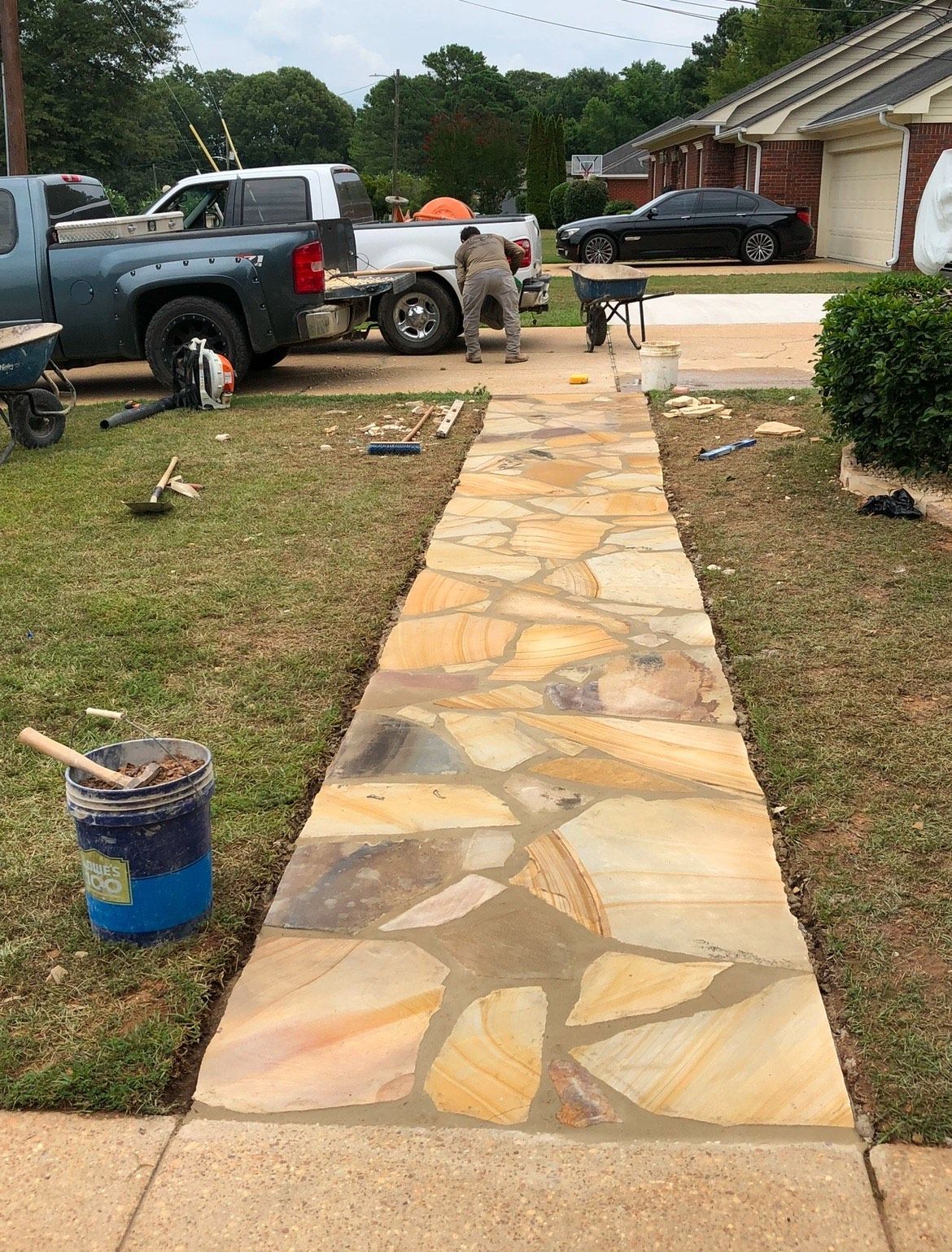 A stone walkway is being built in front of a house.