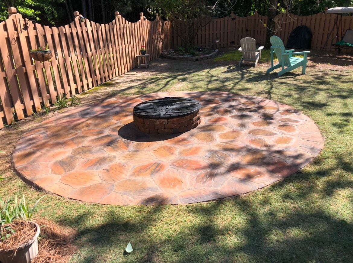 There is a fire pit in the middle of the backyard.