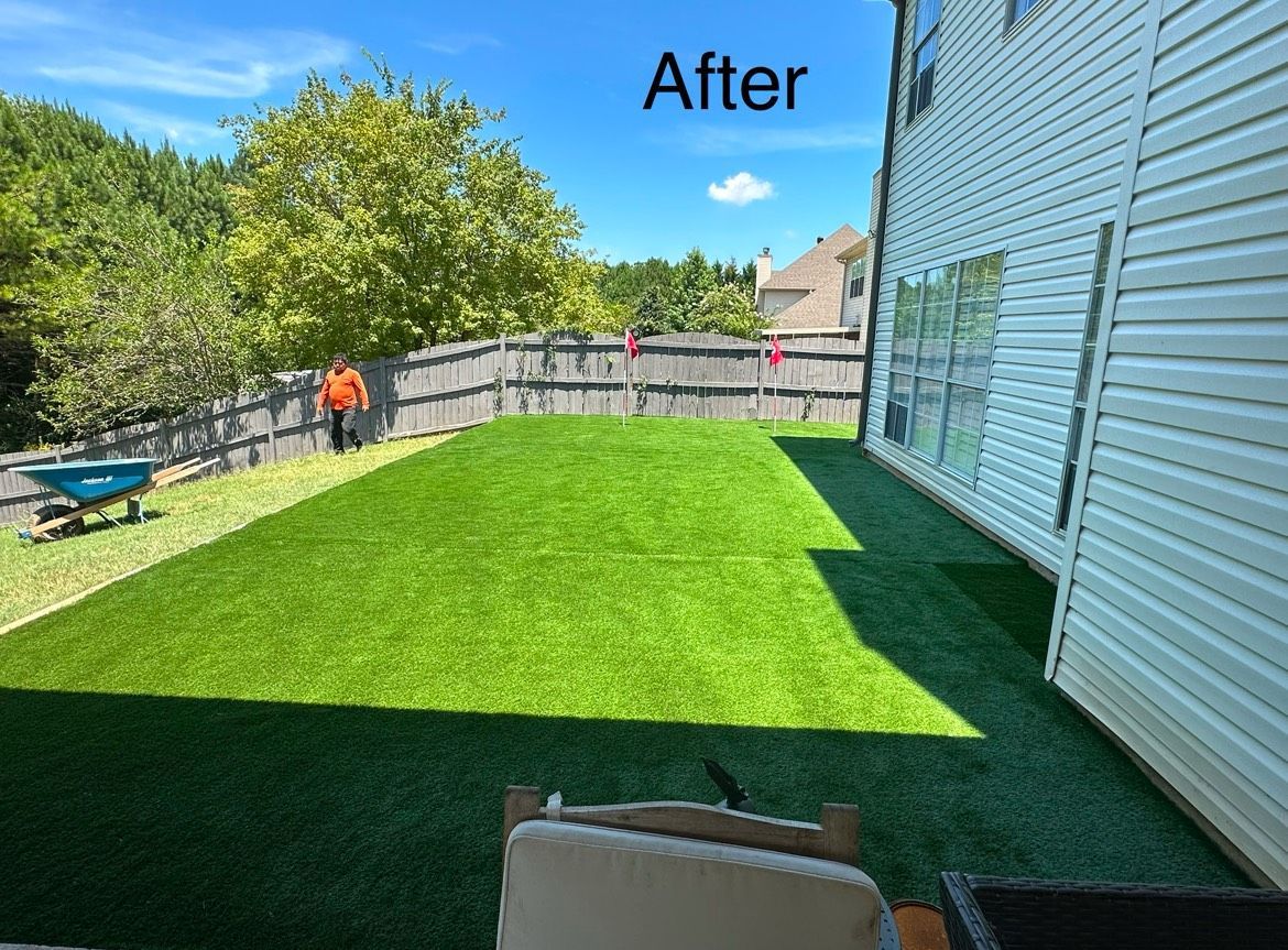A picture of a backyard with a lush green lawn and a fence.