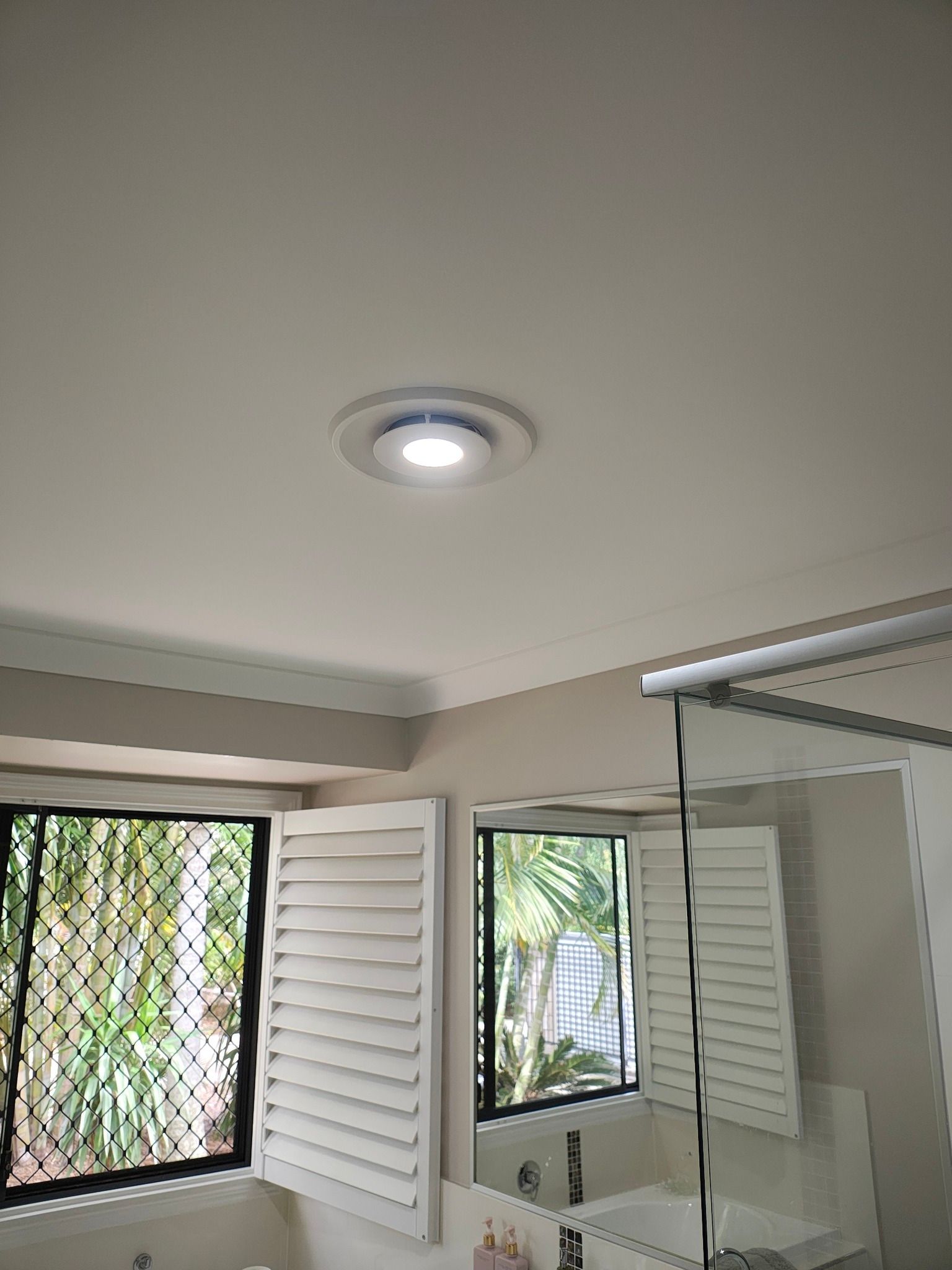 Bathroom Ceiling With a Light Fixture, Windows, and White Shutters — NTR Electrical In Toogoom, QLD