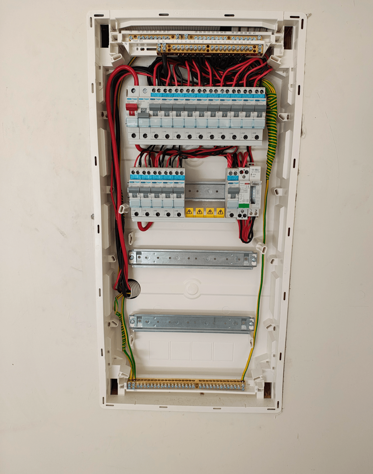 Electrical panel with numerous circuit breakers, wires, and grounding in a white enclosure — NTR Electrical In Toogoom, QLD