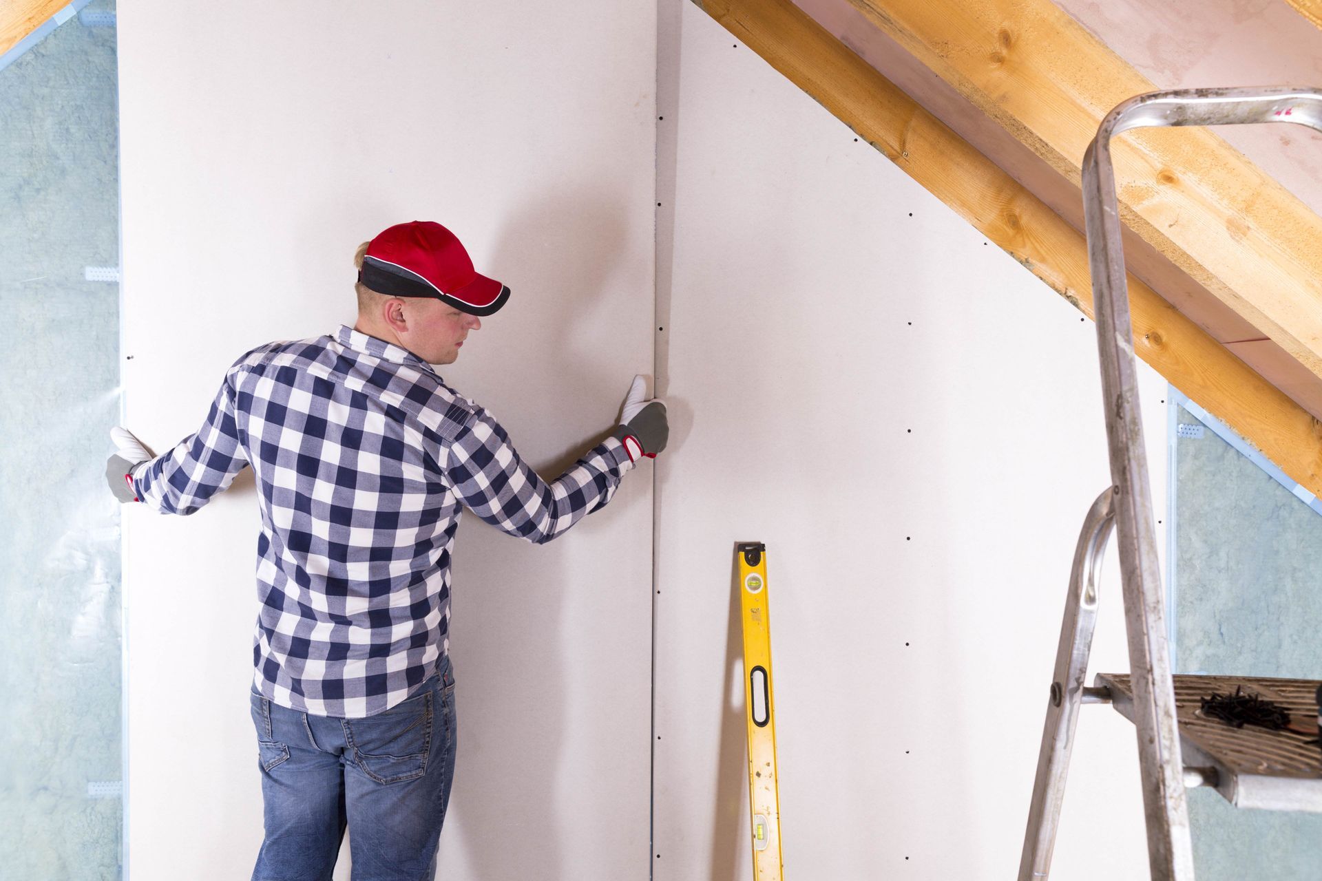 a man is working on a wall with a level