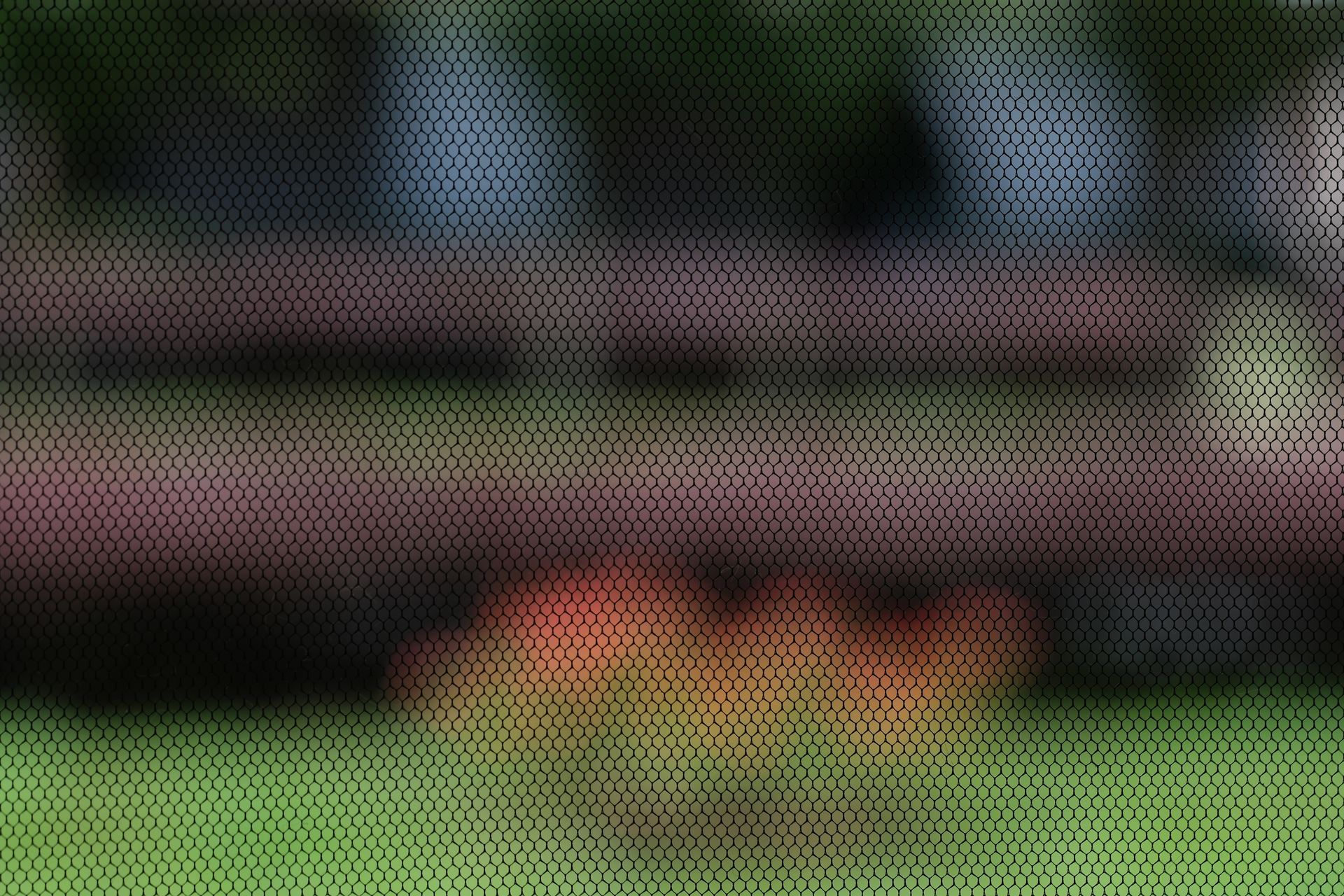 Sfondo sfocato con tonalità di rosso, verde e blu su una trama a rete modellata.