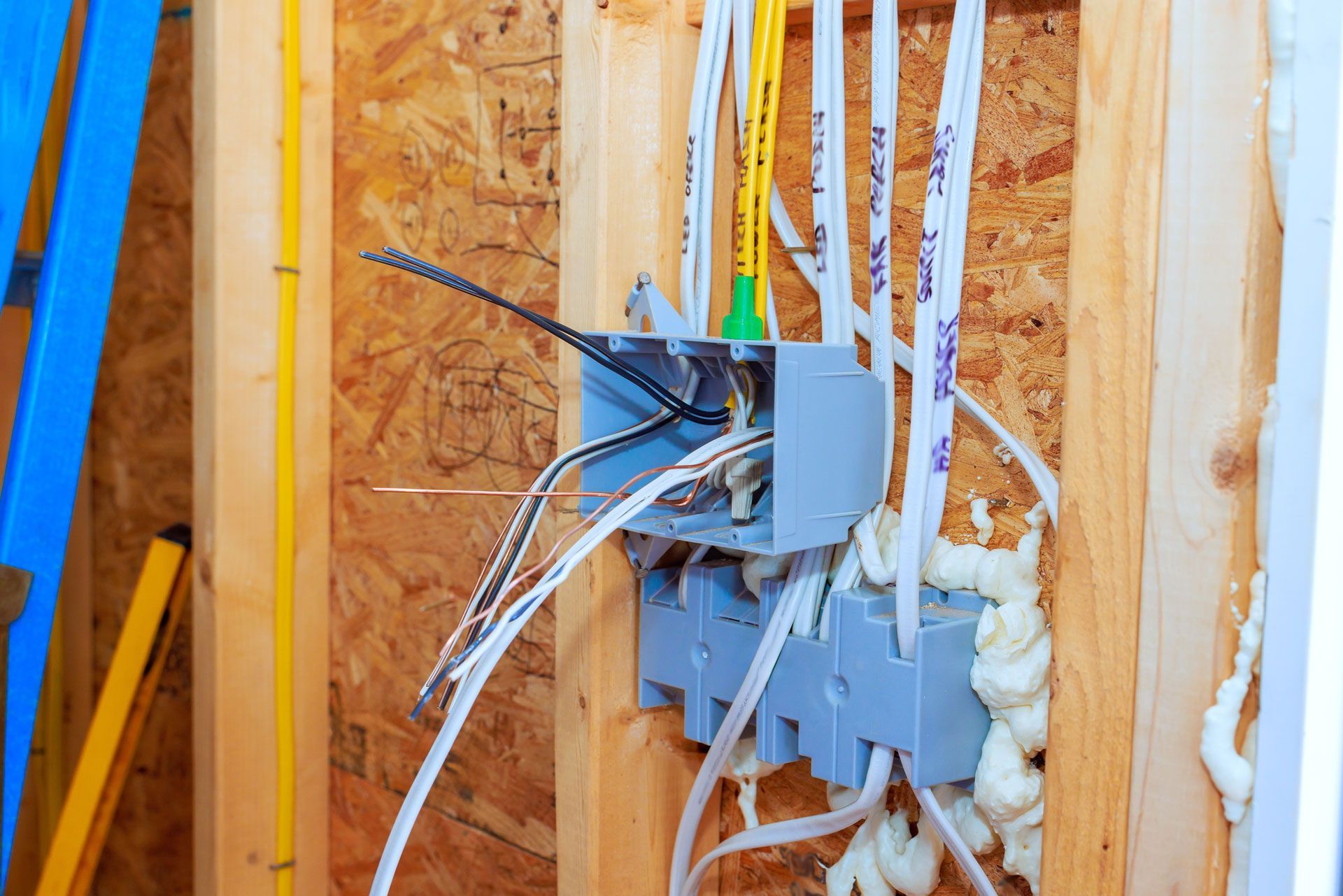 Electrical wiring in a wall stud bay with an open junction box and spray foam insulation