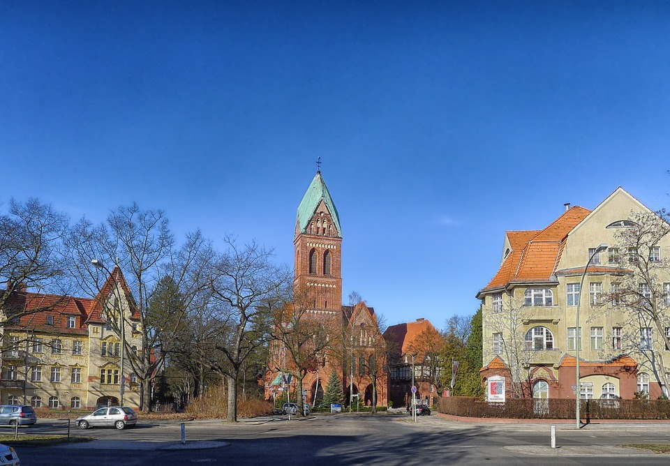Ein großes Backsteingebäude mit Gründach ist von anderen Gebäuden umgeben.