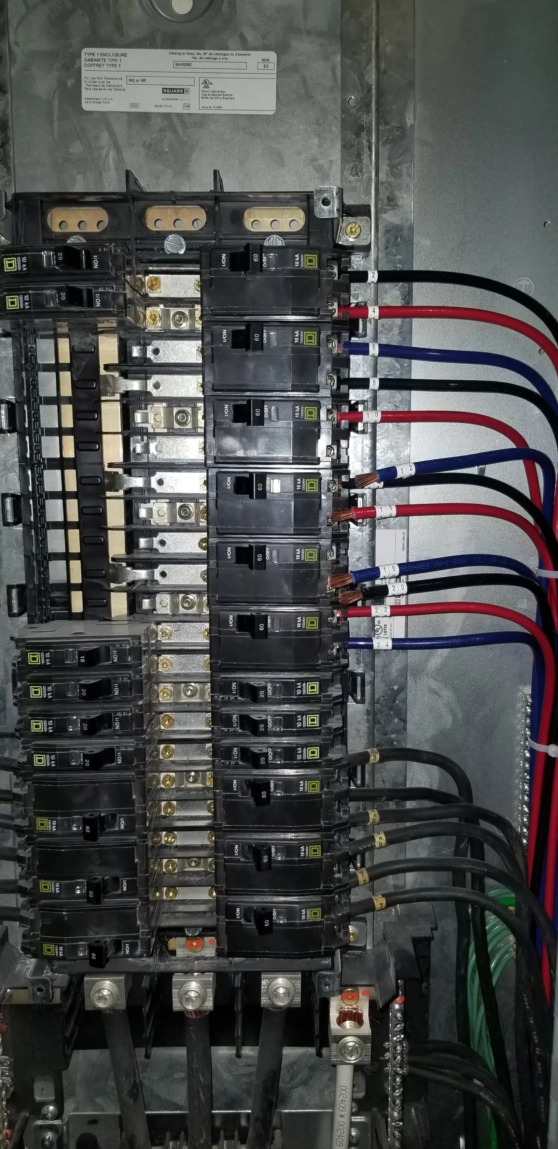 A close up of a electrical panel with a lot of wires coming out of it.