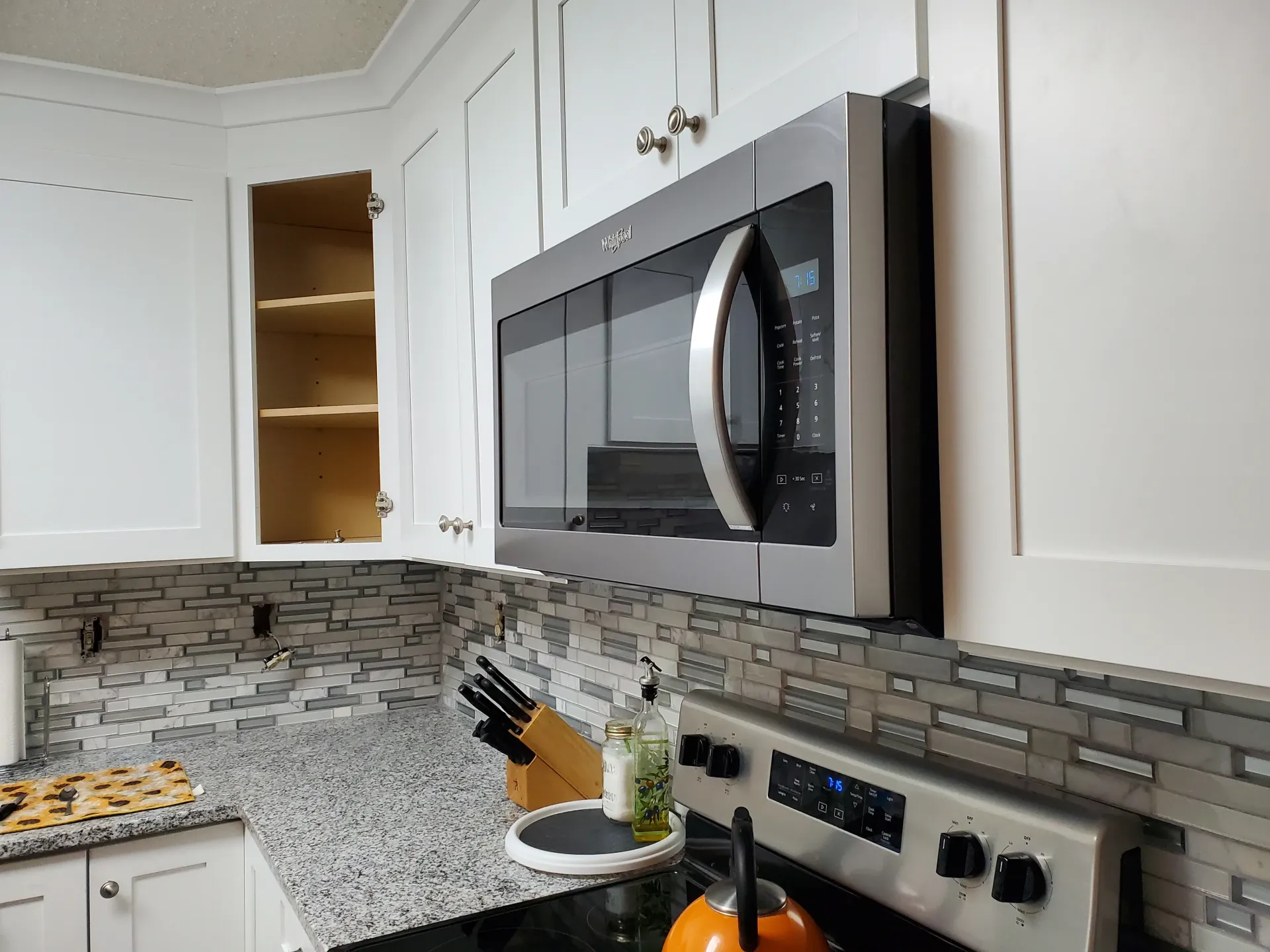 A kitchen with a microwave oven above the stove.