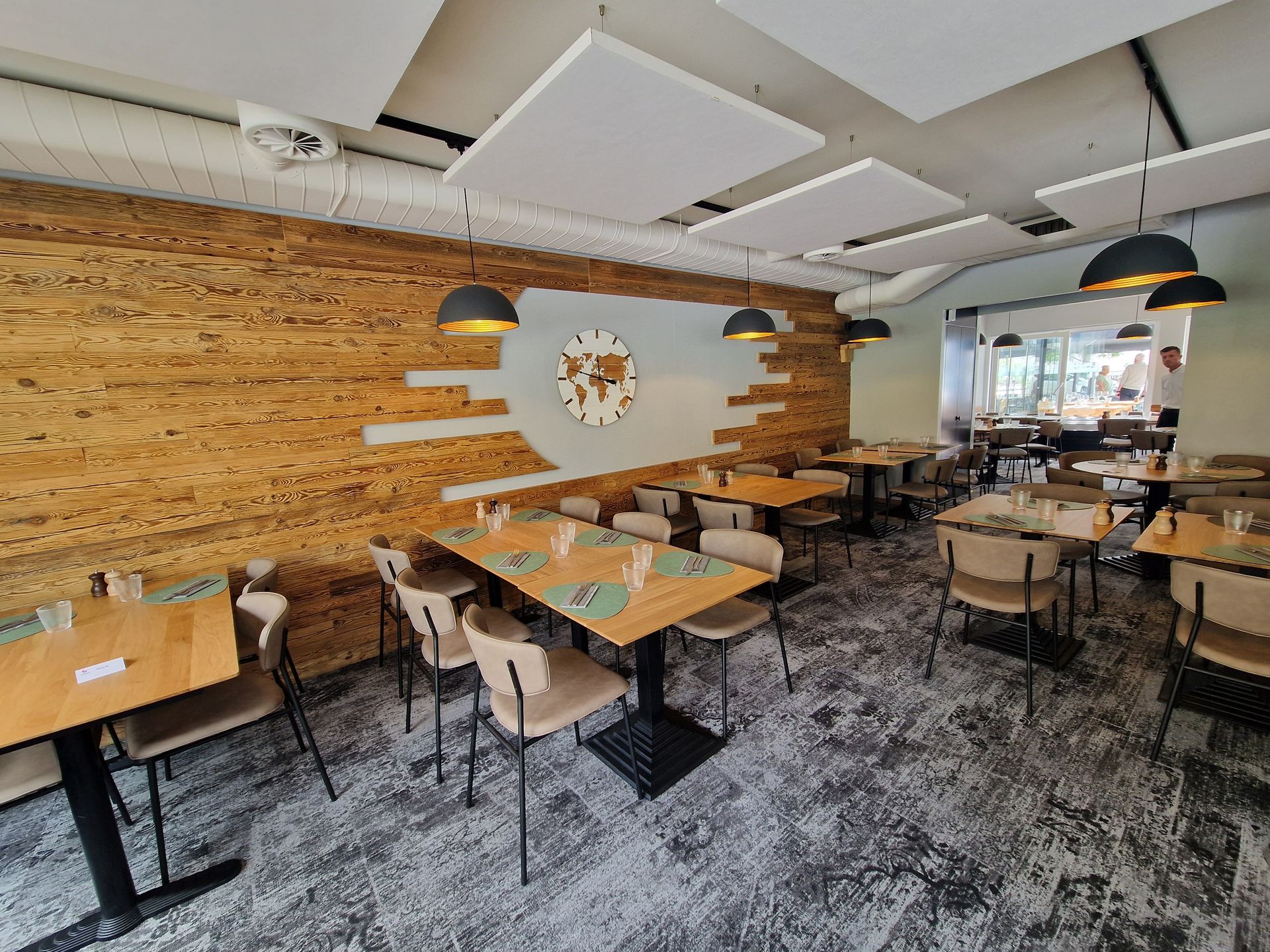 Un restaurant avec des tables et des chaises et une horloge au mur.