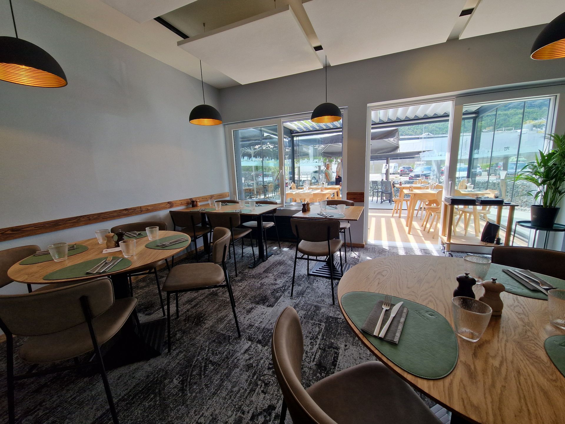 Un restaurant avec des tables et des chaises et beaucoup de fenêtres.