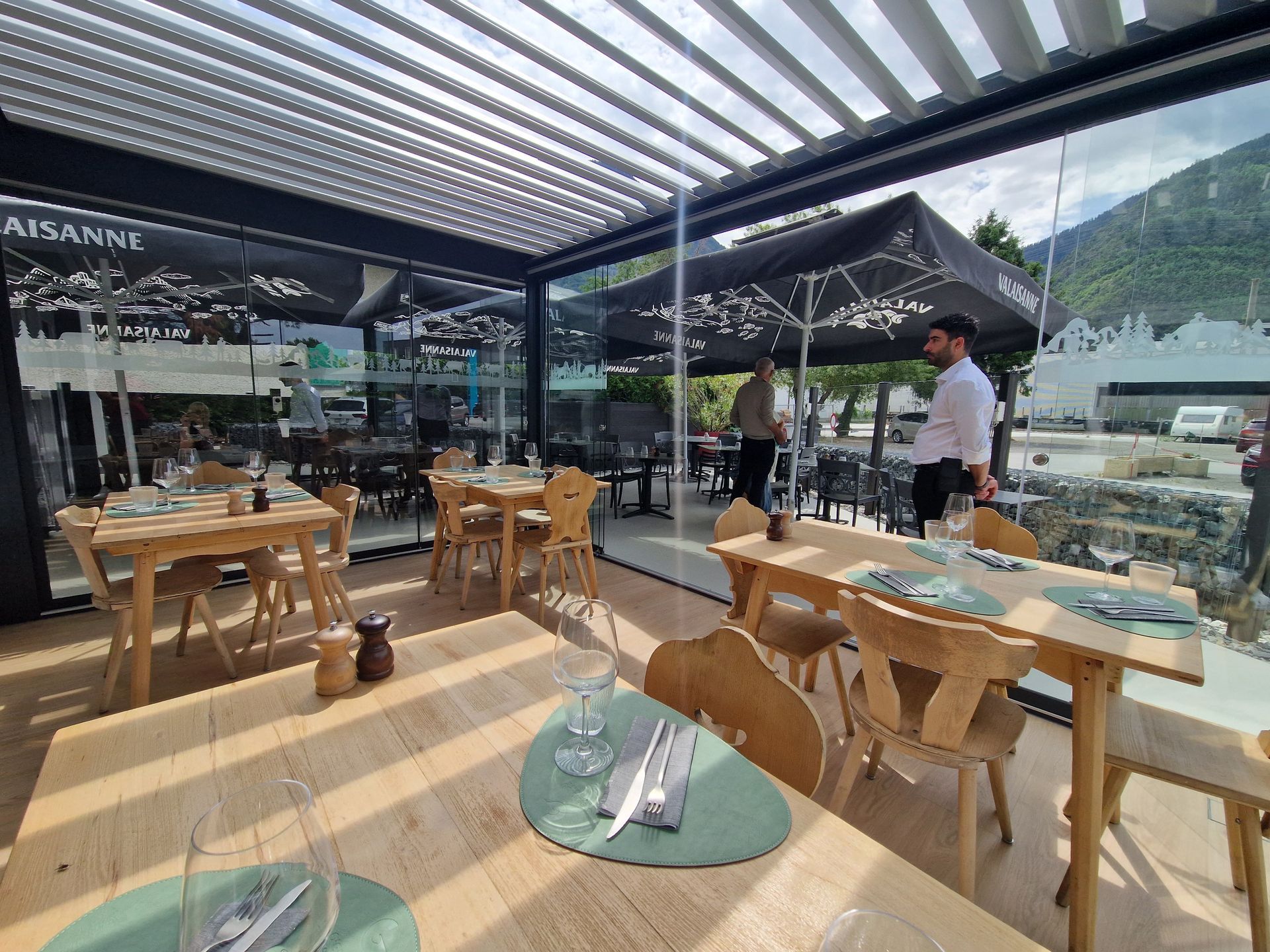 Un restaurant avec tables et chaises sous une pergola.