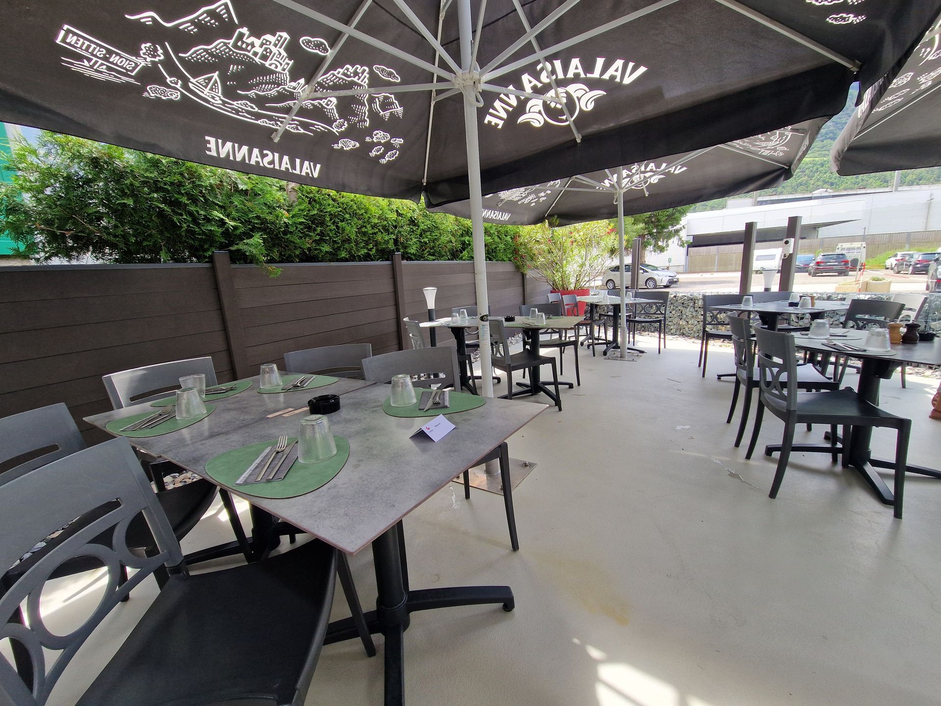 Un restaurant avec tables et chaises sous parasols.