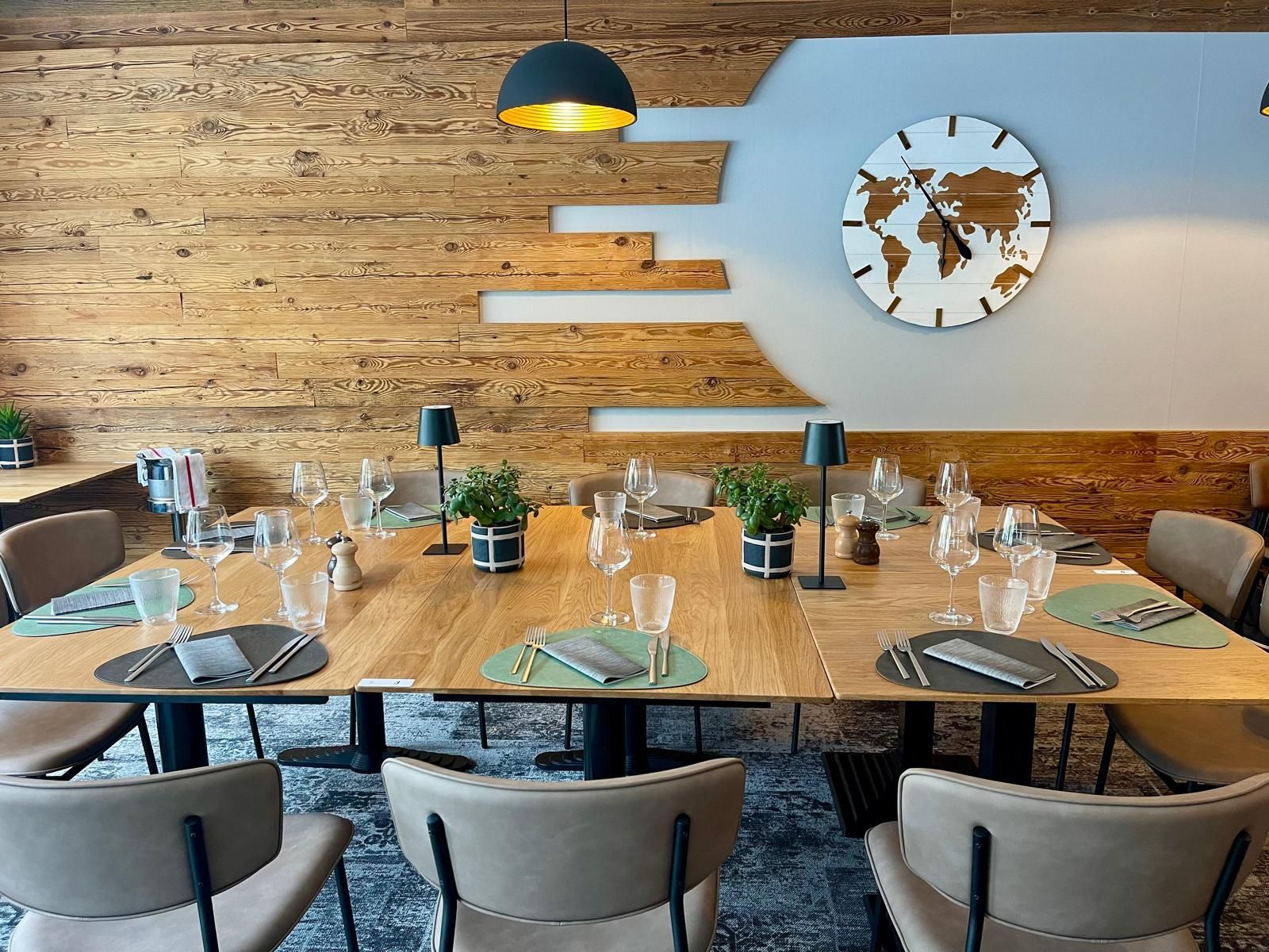 Une salle à manger avec tables et chaises et une horloge au mur.