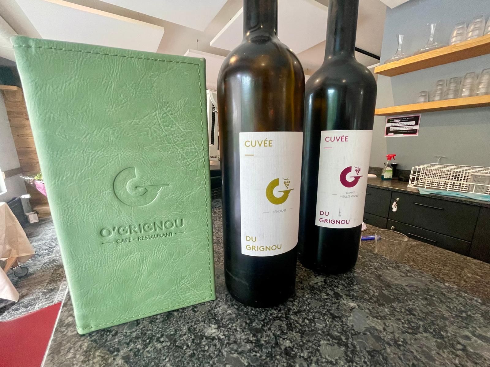 Deux bouteilles de vin sont posées sur un comptoir à côté d'un menu.