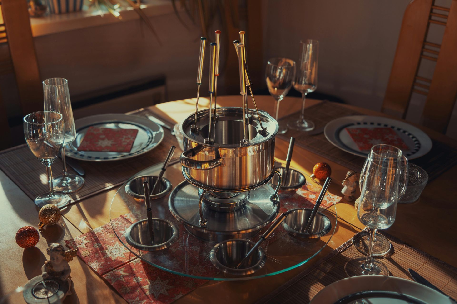 Une table dressée pour une soirée fondue avec assiettes et verres à vin
