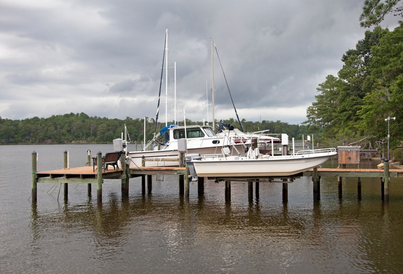 Two boats are docked at a dock on a cloudy day