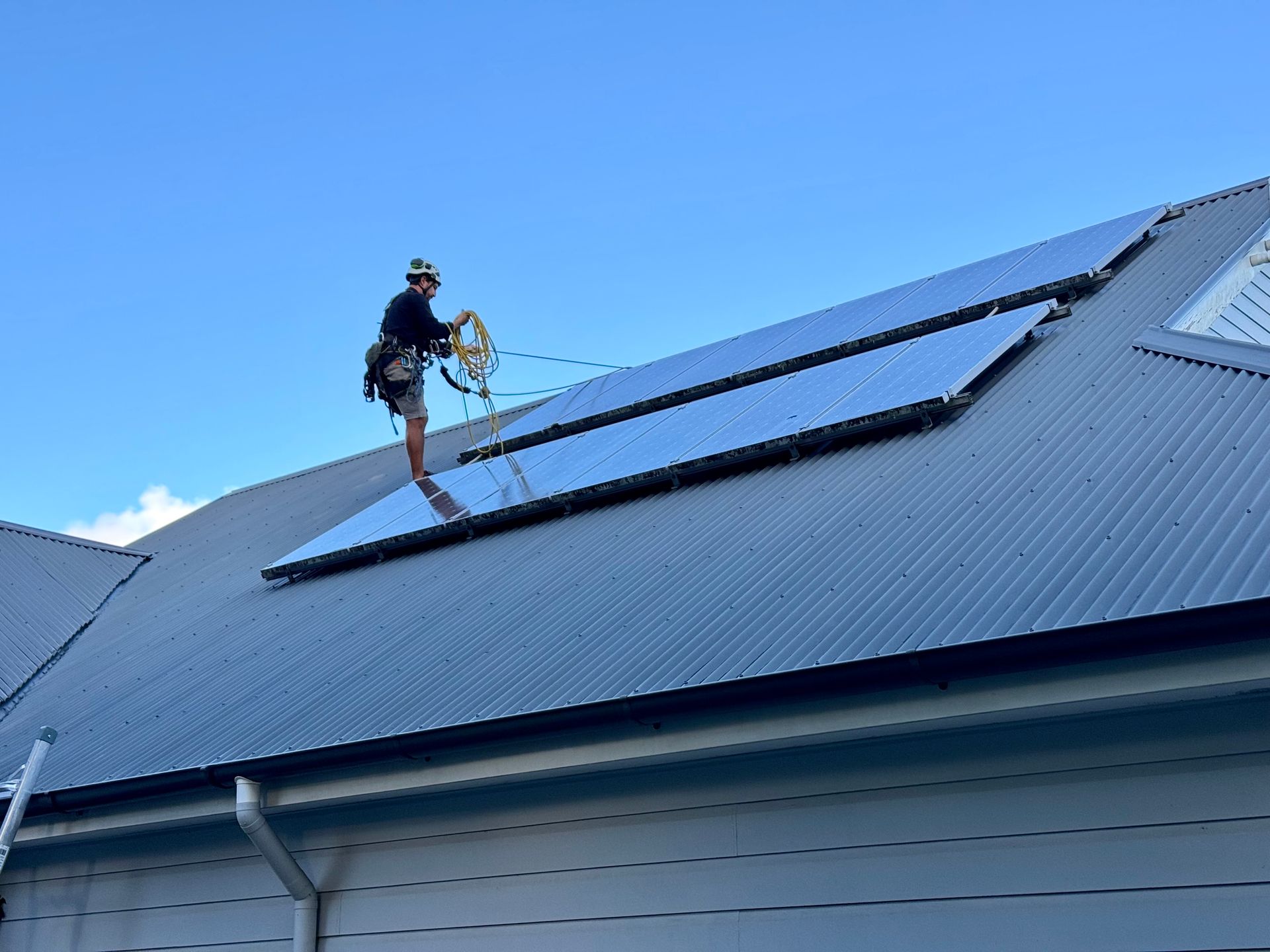 A Man Is Cleaning The Windows Of A Tall Building — Freshwater Exterior Cleaning in Lennox Head, NSW