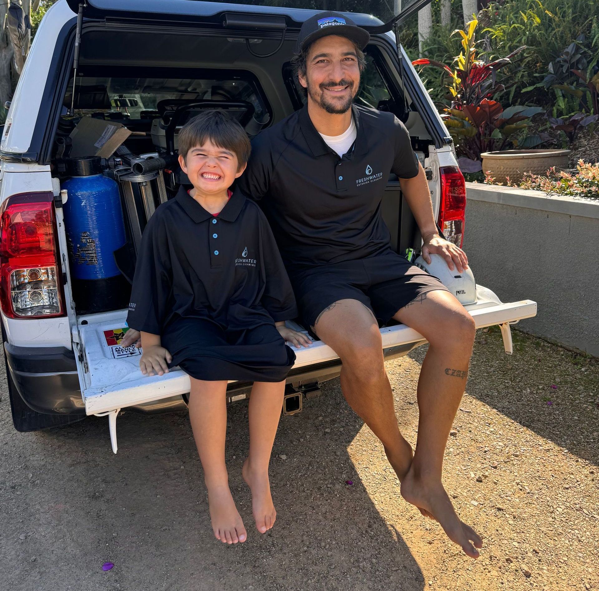 A Man and Son Sitting on the end of a Ute — Freshwater Exterior Cleaning in Lennox Head, NSW