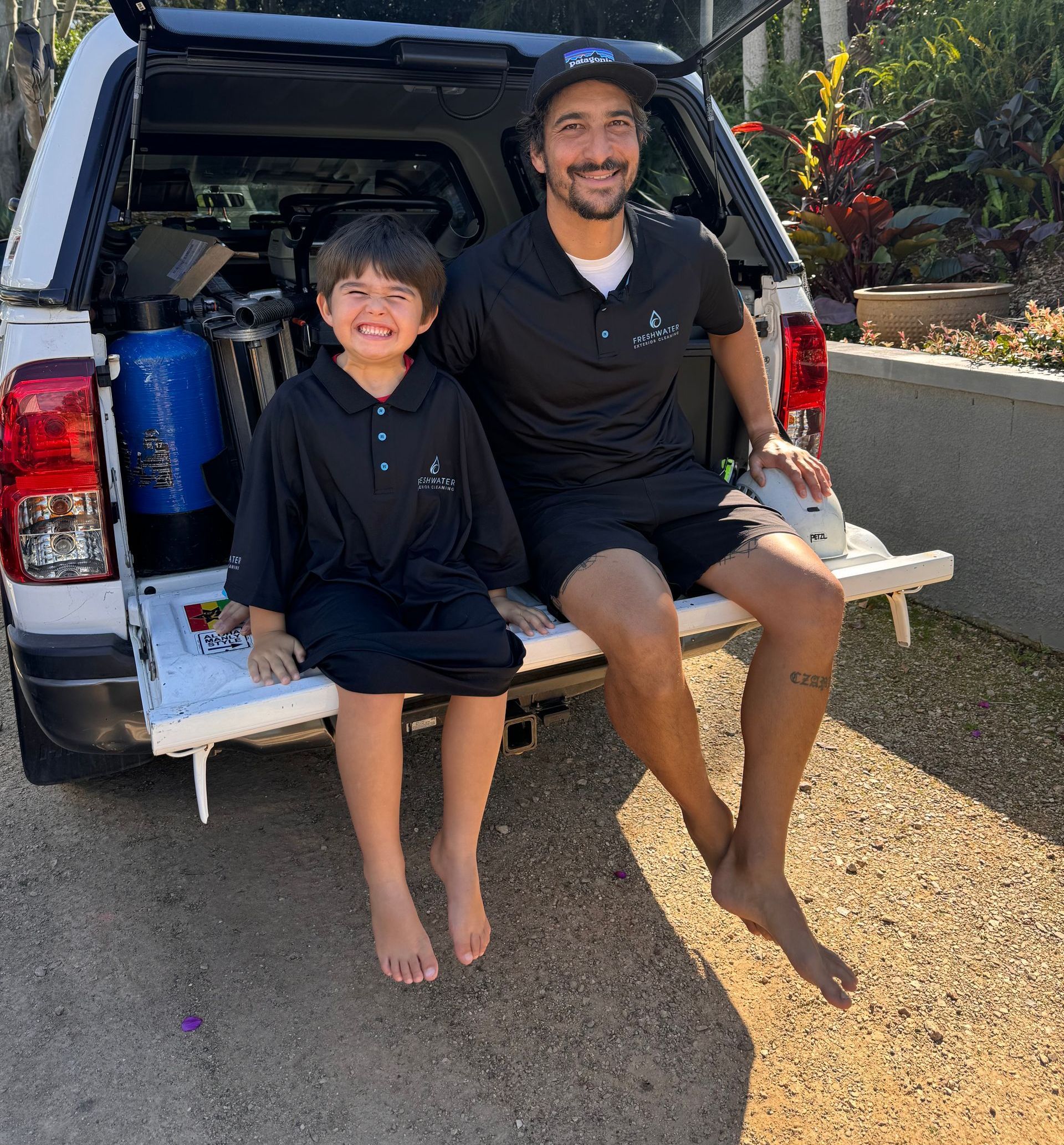 Two People Sitting On End Of Ute In Cleaning Uniforms — Freshwater Exterior Cleaning in Alstonville, NSW