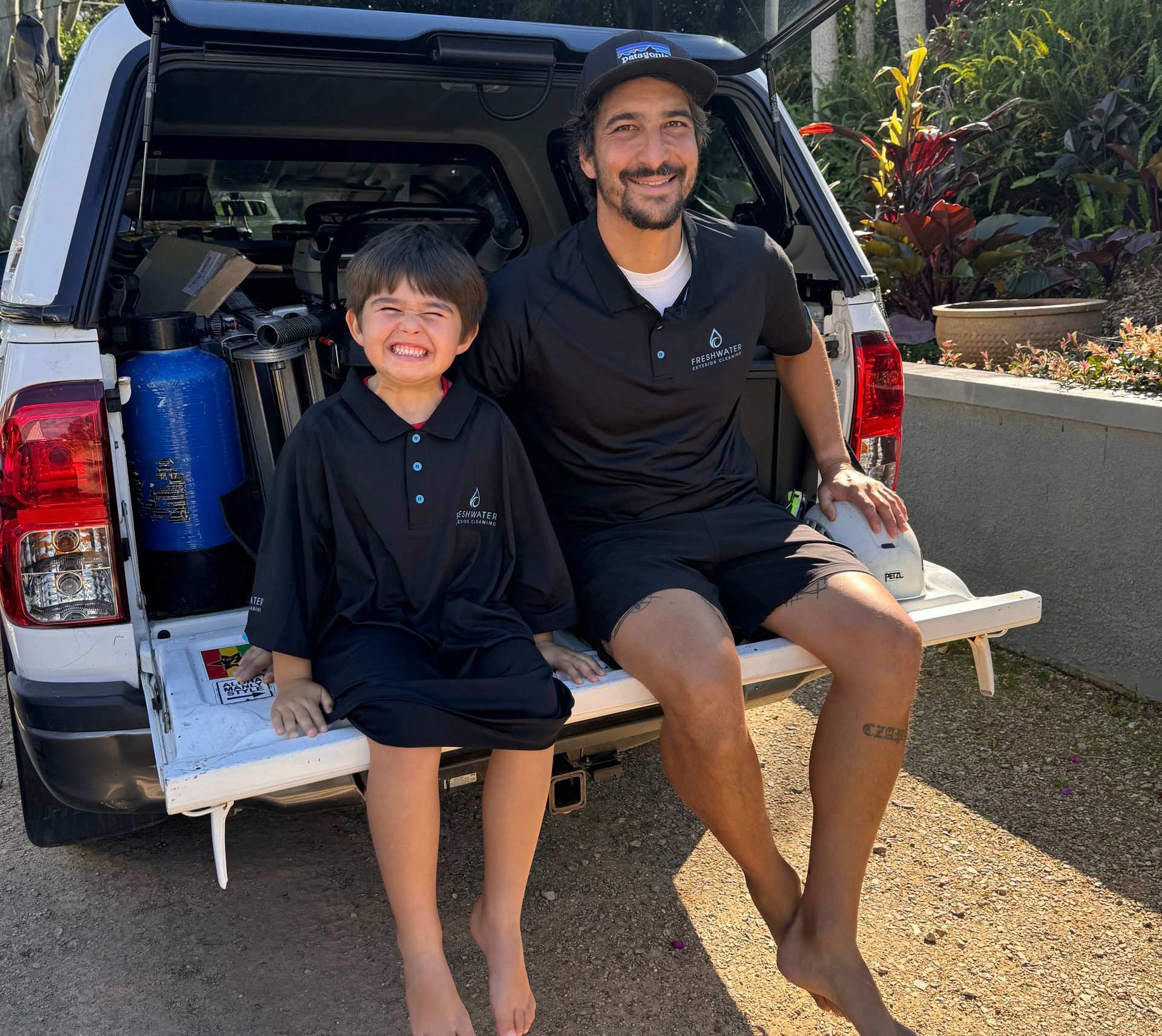 Man and Son sitting on the end of a ute — Freshwater Exterior Cleaning in Bayron Bay, NSW