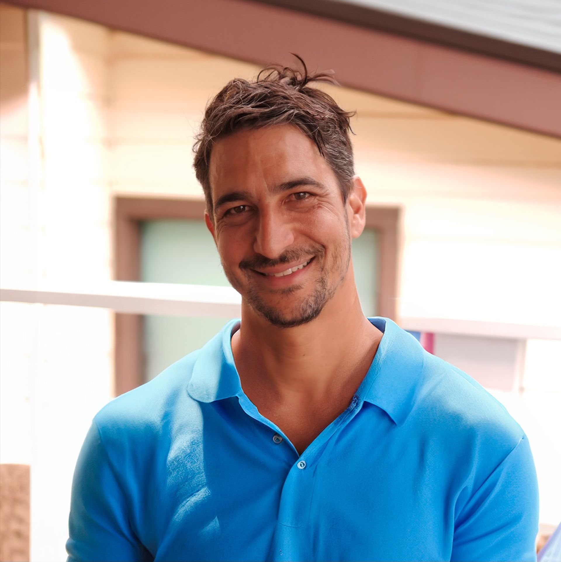 A Man Is Standing On Top Of A Building With His Arms Outstretched — Freshwater Exterior Cleaning in Lennox Head, NSW
