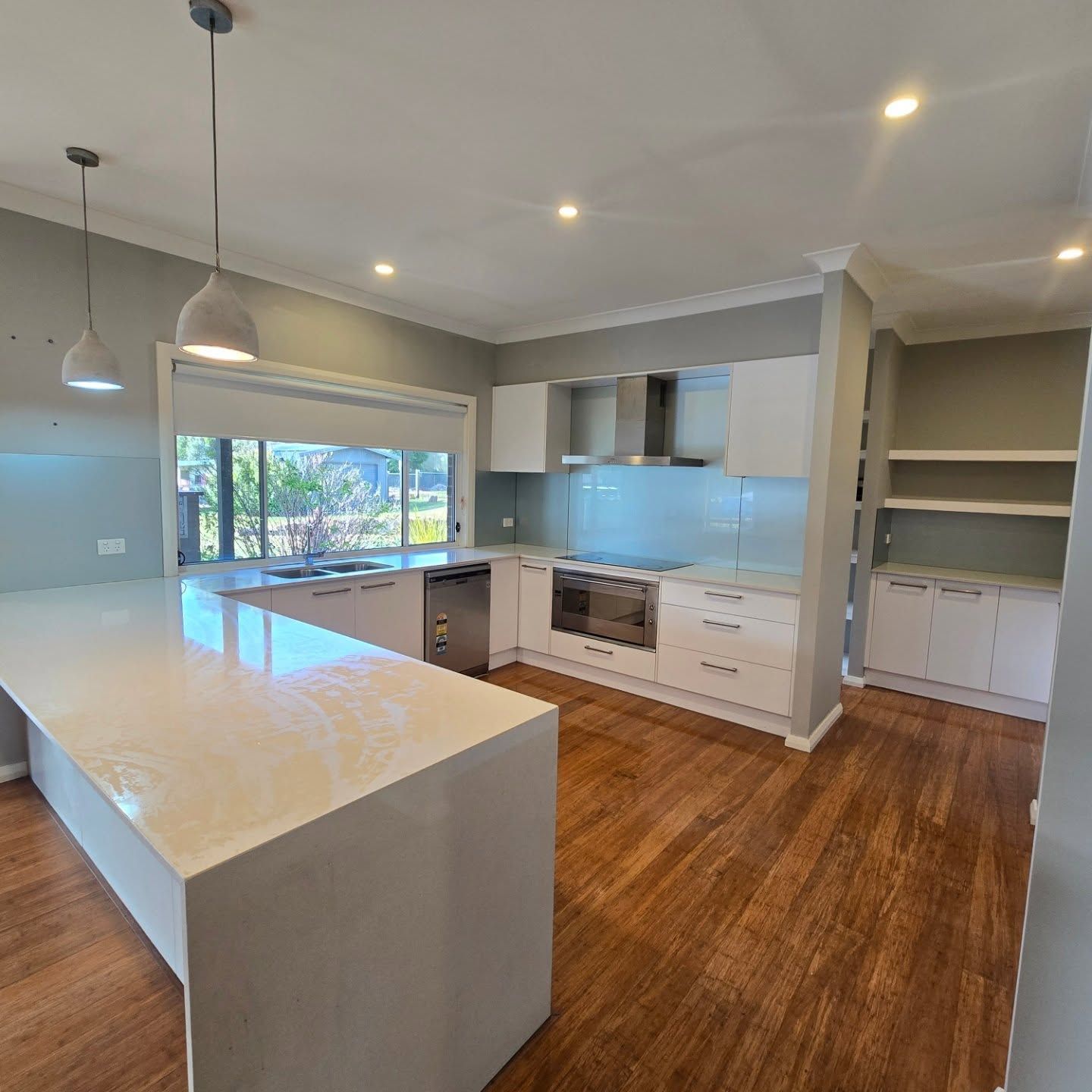 An Empty Kitchen With Marble Floor  In Centre And Two Hanging Lamps — A Perfect Move And Clean In Welby NSW 