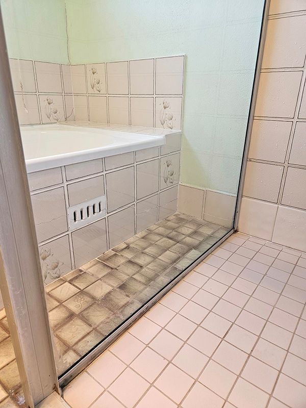 Bathroom with Bathtub Having Square Tiles and Open door — A Perfect Move And Clean In Mittagong NSW