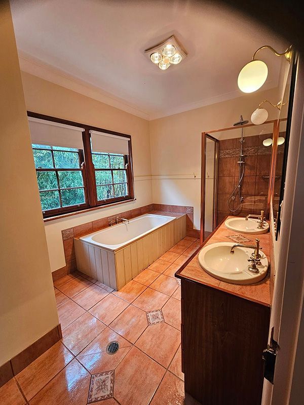 Beautiful Brown Themed Bathroom with Lights on Ceiling, Bathtub and Bathroom Sink — A Perfect Move And Clean In Moss Vale NSW