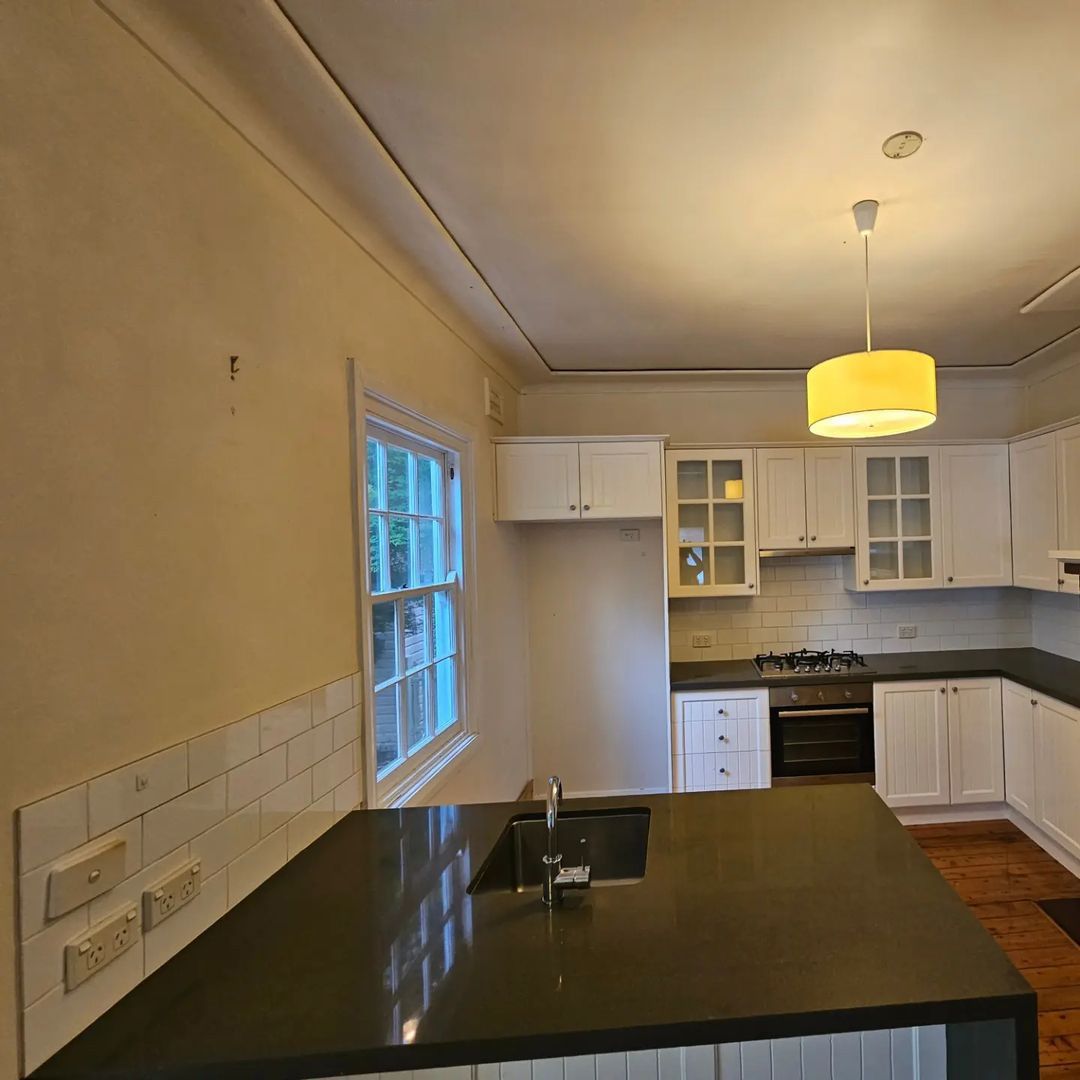 Beautiful Kitchen with Black Counter Top and White Cabinets — A Perfect Move And Clean In Mittagong NSW