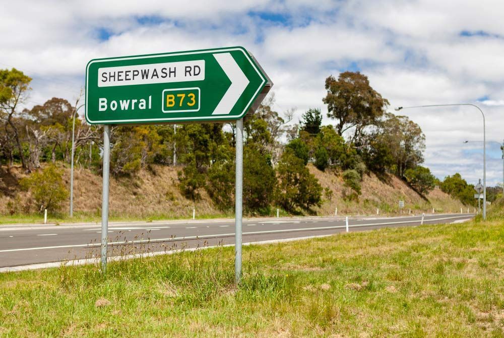 Road Sign Pointing to Right, besides a Road in Bowral — A Perfect Move And Clean In Bowral NSW
