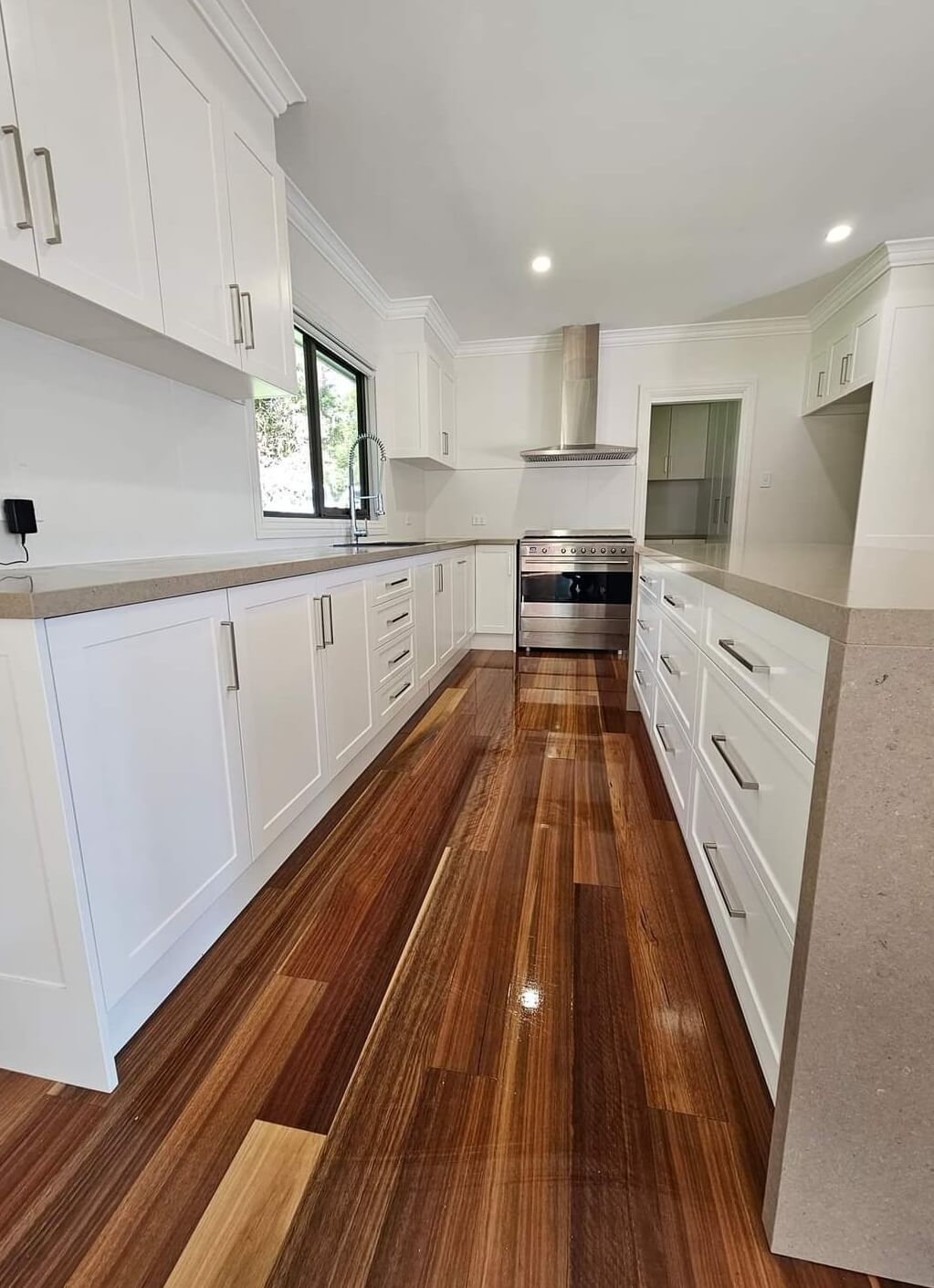 A Kitchen With White Cabinets And Reflective Wooden Floor — A Perfect Move And Clean In Welby NSW