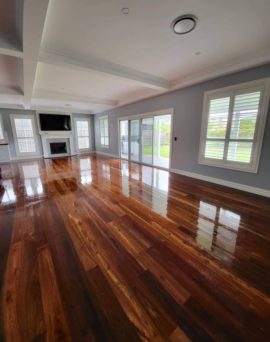 A Big Spacious Living Room With A Fireplace And Sliding Glass Doors — A Perfect Move And Clean In Welby NSW