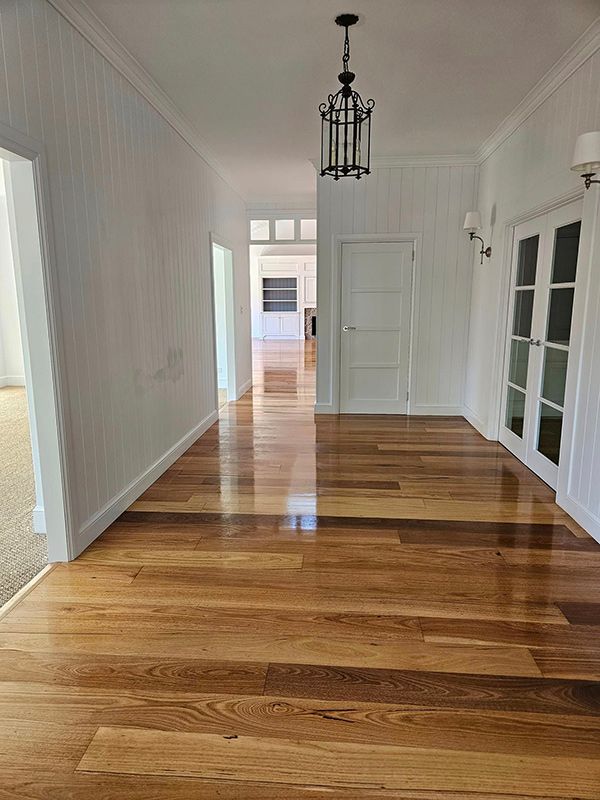 Wooden Floor House with White Walls and Two Lamps on Right side which are either side of the Door — A Perfect Move And Clean In Bowral NSW