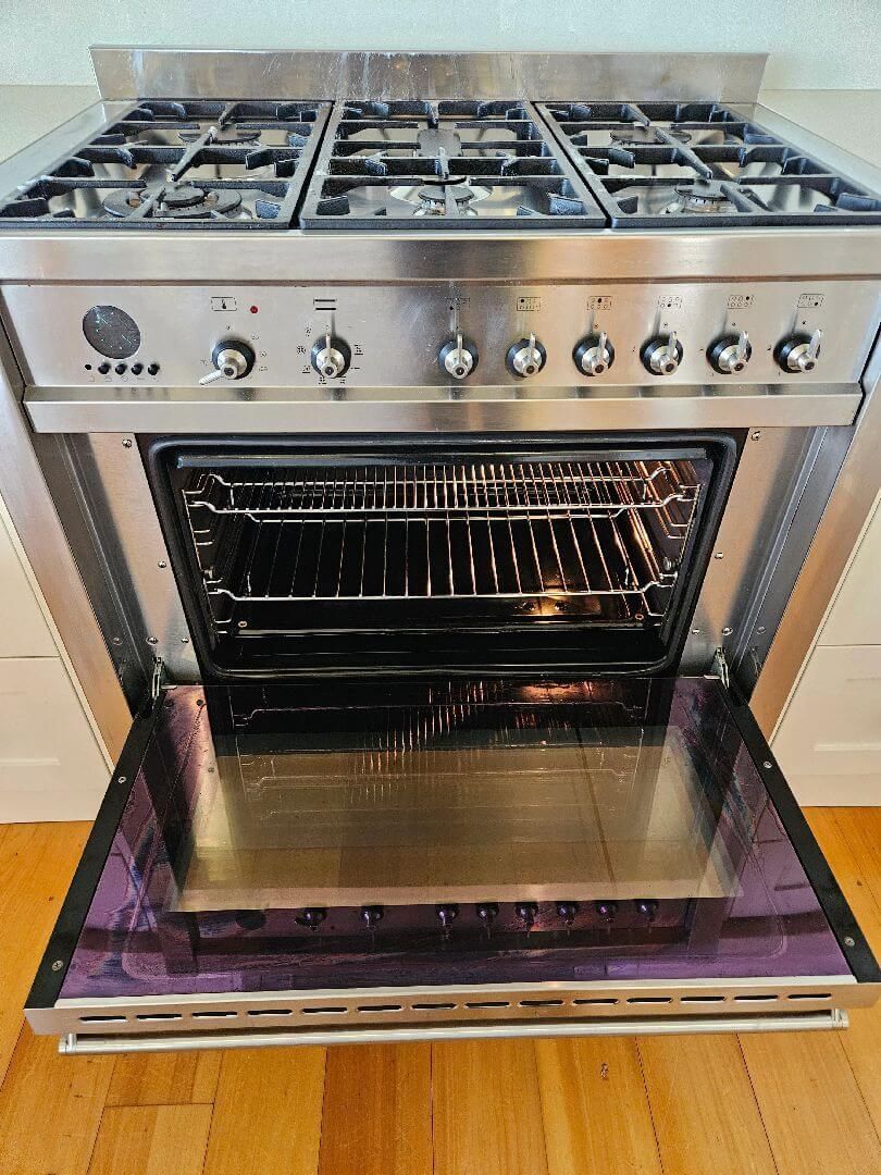 A Stainless Steel Stove Top Oven with The Door Open — A Perfect Move And Clean In Welby NSW