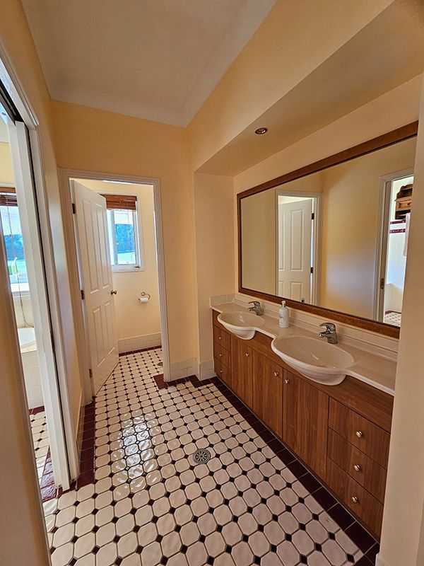 Two Bathroom Sink with Large Mirror and a open Door— A Perfect Move And Clean In Bowral NSW
