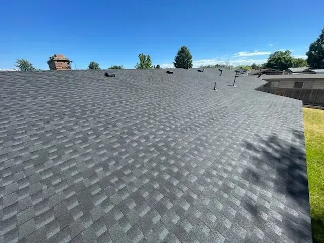 A roof with a lot of shingles on it and a blue sky in the background.