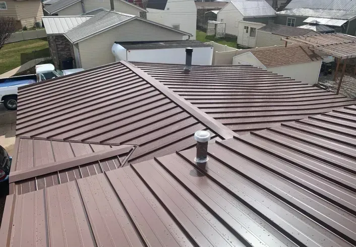 A brown metal roof with a chimney on top of it.
