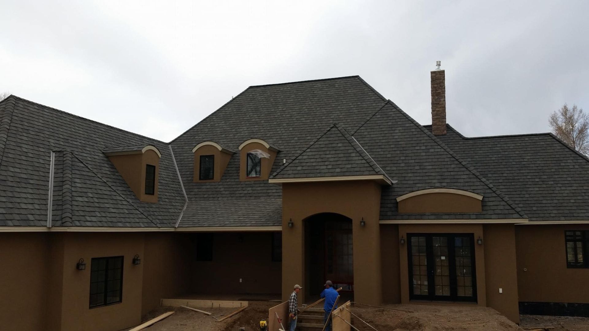 A large house with a gray roof and a chimney