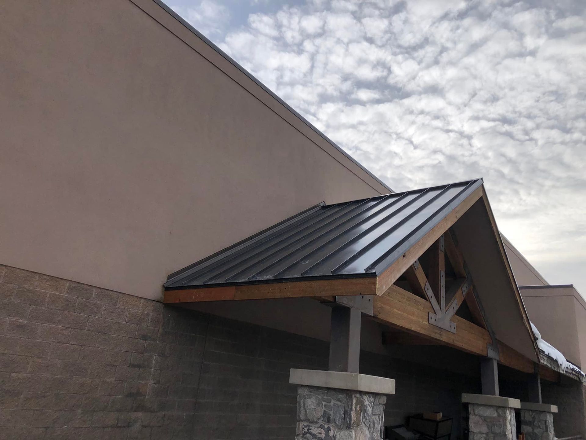 A building with a metal roof and stone pillars