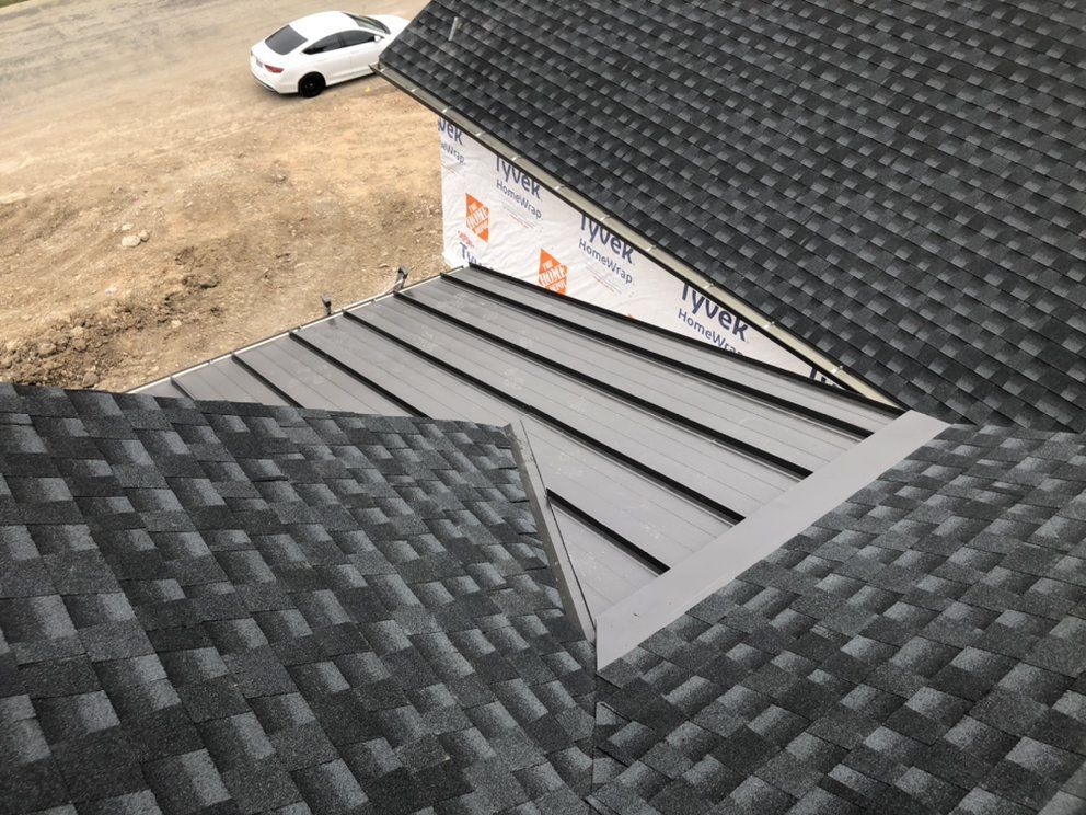 A white car is parked on the side of a building next to a black roof.